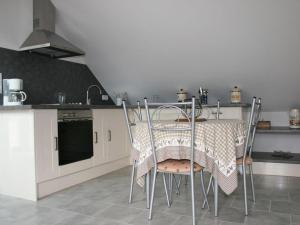 una cocina con mesa y sillas. en Au gîte du treuil, en Monchy-au-Bois