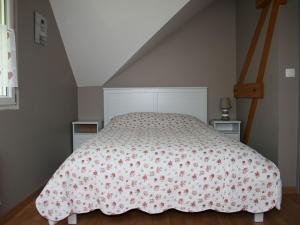 um quarto com uma cama com colcha floral em Au gîte du treuil em Monchy-au-Bois