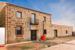 an old brick building with a balcony on the side at Casa Rural La Abacería in Mino de Medinaceli