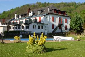 una gran casa blanca con una piscina frente a ella en Chez Bouchet en Licq-Athérey