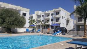 einem Pool vor einem Apartmentgebäude in der Unterkunft Oceania Bay Village in Pyla