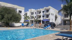 a swimming pool in front of a apartment building at Oceania Bay Village in Pyla