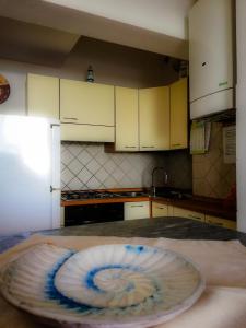 una cocina con armarios blancos y una mesa con una placa. en A Cà d'Assunta, en Laigueglia