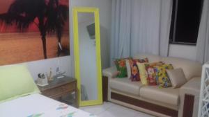 a living room with a mirror and a couch at Ap aluguel no Guaibim in Guaibim