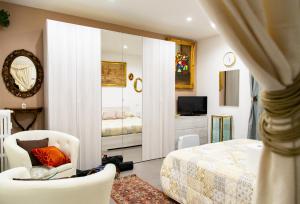 a bedroom with a bed and a tv and a mirror at First House Posillipo in Naples