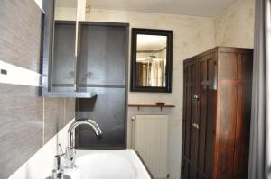 La salle de bains est pourvue d'un lavabo et d'un miroir. dans l'établissement Chambres d'Hôtes L'Alezan, à Orry-la-Ville