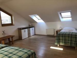 a attic room with two beds and two windows at BIO Farma & Penzión Zlatý Hýľ in Nováčany