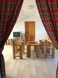 a living room with a table and chairs and a curtain at BIO Farma & Penzión Zlatý Hýľ in Nováčany