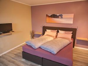 um quarto com uma cama e uma televisão na parede em Ferienwohnung Eggeblick em Altenbeken