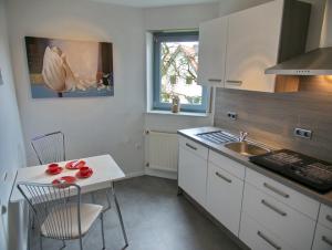 cocina con fregadero y mesa con sillas en Ferienwohnung Eggeblick, en Altenbeken