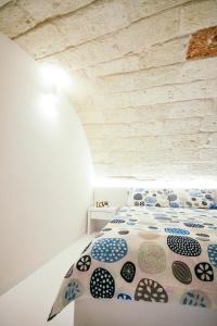 a bedroom with a bed in a white room at COCCA - Le charme de Casa Mia in Polignano a Mare