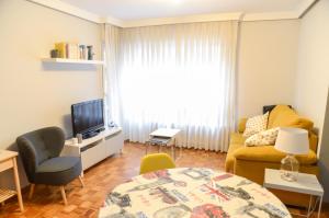een woonkamer met een bank en een tv bij COSTA 123 in Gijón