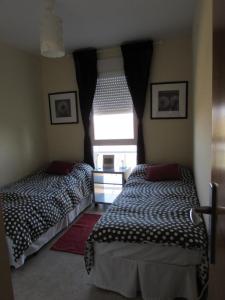 two beds in a room with a window at Apartamento La Figuereta, Isla Cristina in Isla Cristina