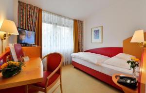a hotel room with a bed and a desk at Hotel Spiegel in Cologne