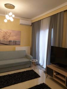 uma sala de estar com um sofá e uma televisão em THESS OLD TOWN with free private parking em Tessalônica
