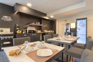 a restaurant with tables and chairs and a kitchen at Best Western Hôtel Journel Paris Sud in Ris-Orangis