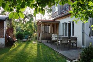a wooden deck with a table and chairs in a yard at Fachwerkhaus am Fluss in Neuhardenberg
