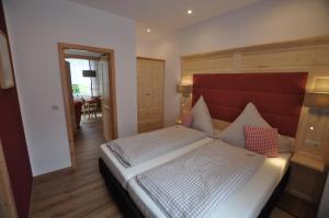 a bedroom with a large bed with a red headboard at Wohlfühl-Ferienwohnungen König in Bad Elster