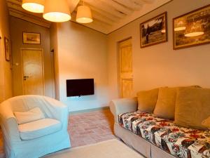 een woonkamer met een bank en een tv bij Podere Il Castellaccio in Castagneto Carducci