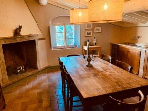 a dining room with a wooden table and a fireplace at Podere Il Castellaccio in Castagneto Carducci