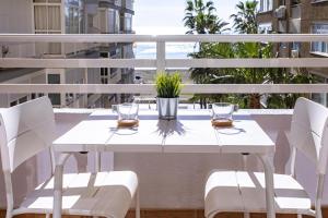 a white table and chairs on a balcony at Malagueta Blue in Málaga