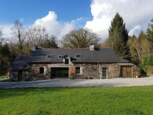 ein großes Steinhaus mit Auffahrt in der Unterkunft Le Parc Lann in Sainte-Brigitte