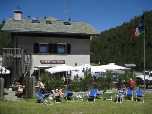 eine Gruppe von Personen, die vor einem Gebäude auf Stühlen sitzen in der Unterkunft Chalet Villa Valania in Valdidentro