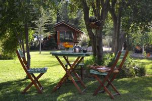 a picnic table and two chairs in a yard at Hostería Meliquina in Lago Meliquina