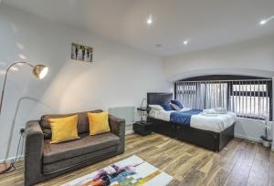 a living room with a bed and a couch at Victoria House Apartments in Leeds