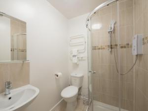 a bathroom with a shower and a toilet and a sink at Victoria House Apartments in Leeds