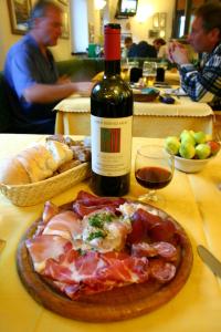 una botella de vino y un plato de comida en una mesa en Chalet Villa Valania, en Valdidentro