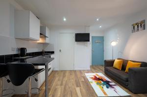 a kitchen and a living room with a couch at Victoria House Apartments in Leeds