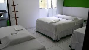 1 dormitorio con 2 camas y pared verde en Pousada Maramazon, en São Luís