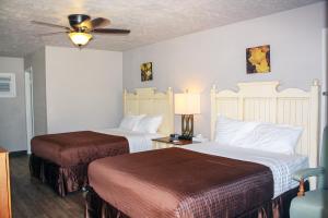 a hotel room with two beds and a ceiling fan at Zwolle Inn in Zwolle