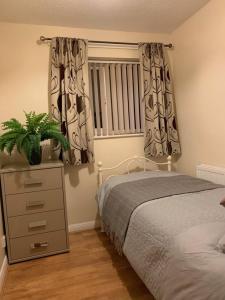 1 dormitorio con 1 cama, vestidor y ventana en 75ers private room en Cheltenham