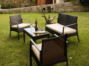 3 chaises et une table avec une bouteille de vin dans l'établissement Hotel A Torre do Xudeu, à Tui