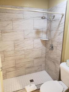 a bathroom with a shower with a toilet at University Inn Fresno in Fresno