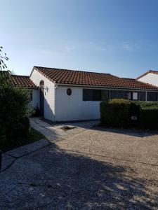 a white house with a red roof and a driveway at Duinenhuis Zeepolder 27 in De Haan