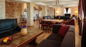 a living room with couches and a table and chairs at Casa Maria Valea Draganului in Lunca Vişagului