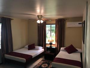 1 dormitorio con 2 camas y ventilador de techo en Overbridge River Resort en Paramaribo