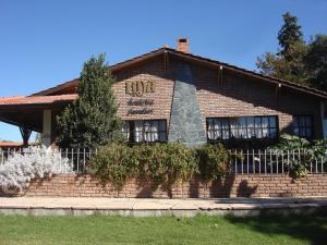 a brick building with a fence in front of it at Hostería Lida in Merlo