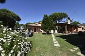 a house with a yard with white flowers at Agriturismo Redipuglia in Alberese