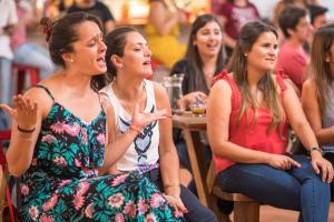 un grupo de mujeres sentadas en una multitud en un evento en Viajero Colonia Hostel & Suites, en Colonia del Sacramento