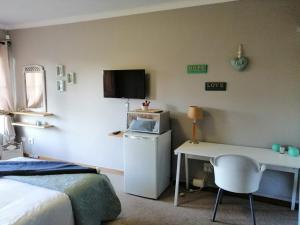 a bedroom with a bed and a desk with a computer at Platberg Self-catering in Harrismith
