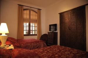a hotel room with two beds and a window at Parador Santa Maria La Real in Sucre