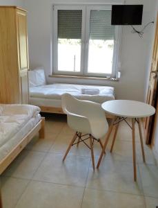 een kamer met een tafel en een bed en een tafel en stoelen bij Lawendowy Zakątek in Kołczewo