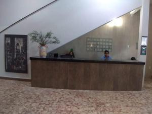 Ein Mann, der an der Rezeption in einem Gebäude sitzt. in der Unterkunft Excelsior Hotel in Caxias das Aldeias Altas