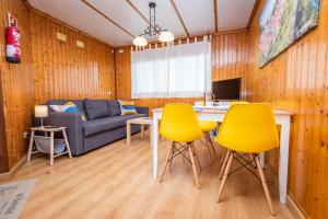 Una sala de estar con sillas amarillas y una mesa. en Apartamentos Cudillero, en Cudillero
