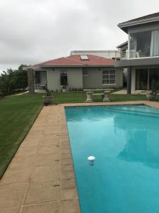 a swimming pool in front of a house at The Cottage on Cordia 2 Bedroom self catering 2km from Umhlanga beach in Durban