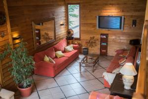 a living room with two red couches and a tv at Los Naranjos in Ushuaia